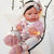 Papusa bebe realist Pipa cu pernuta, cu articulatii, alb-roz, corp realist anatomic, Antonio Juan